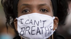 Woman wearing a mask with "I can't breathe" written on it