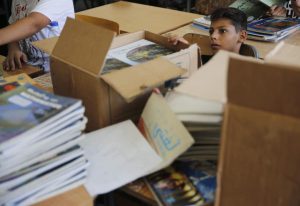 Child sitting with boxes of books